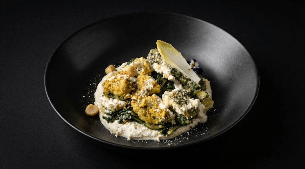Gnocchi paglia e fieno con cicoria cimata e stracciatella di macadamia