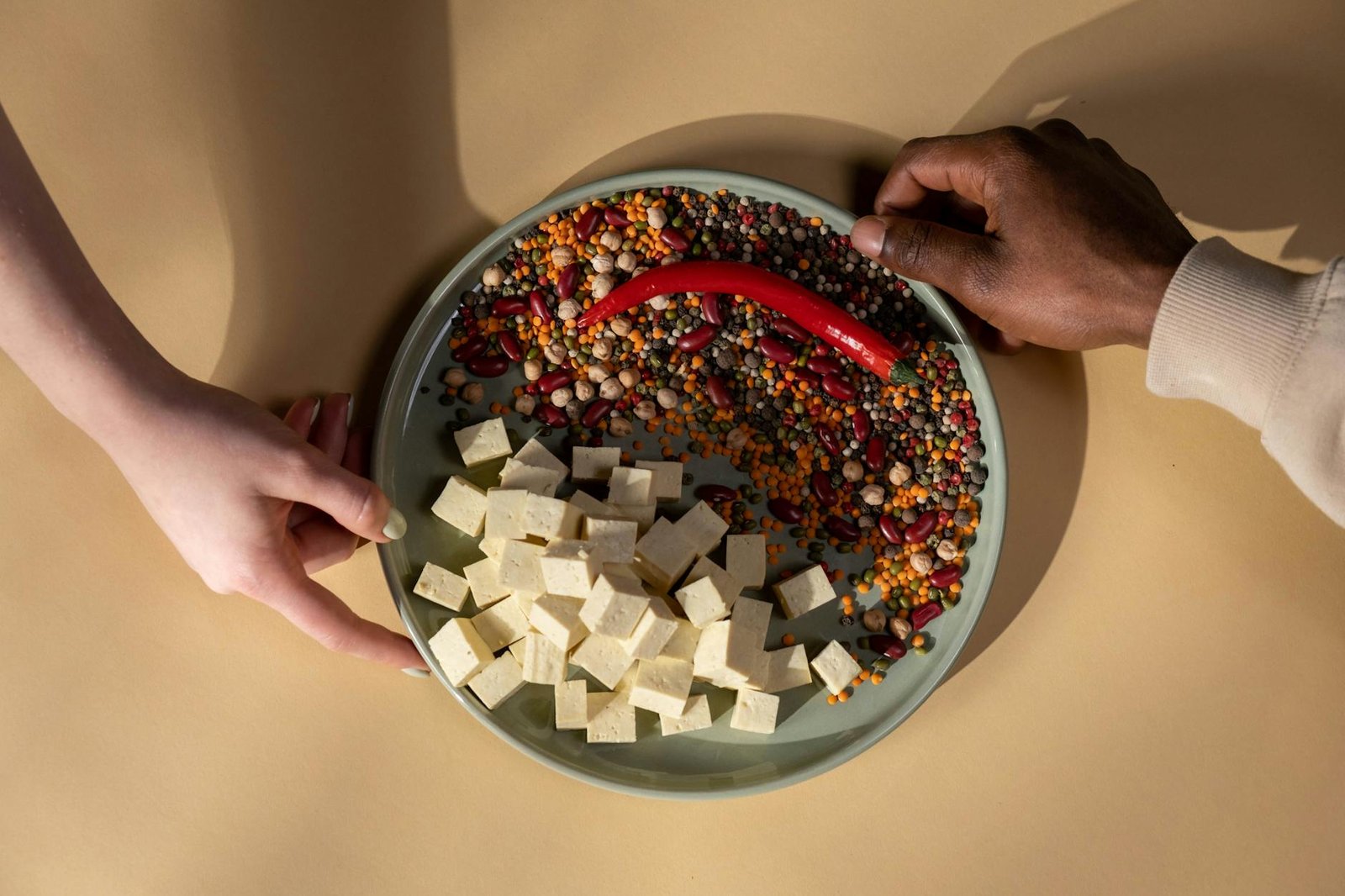 person holding white ceramic bowl with red and white food