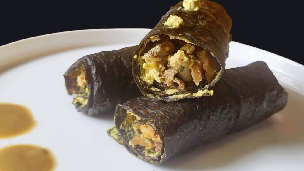 Crespelle crudiste di champignon e zucchine con ragù di porcini, jackfruit e burro di girasole fermentato