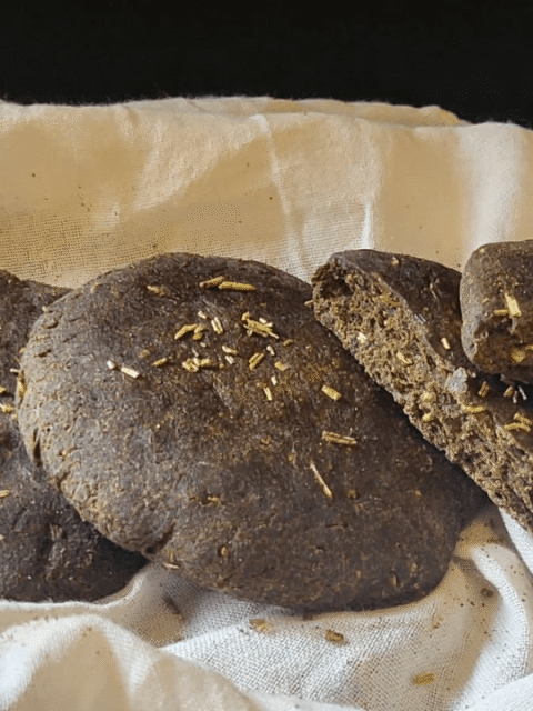 Focaccine di pane scure su tovagliolo bianco