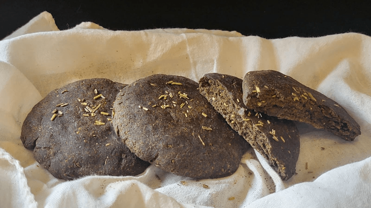 Focaccine di pane scure su tovagliolo bianco