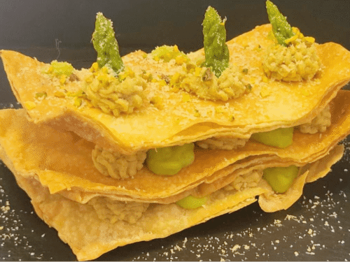 Sfoglie di pasta fillo intervallate da spuntoni di creme colorate su piatto nero ardesia