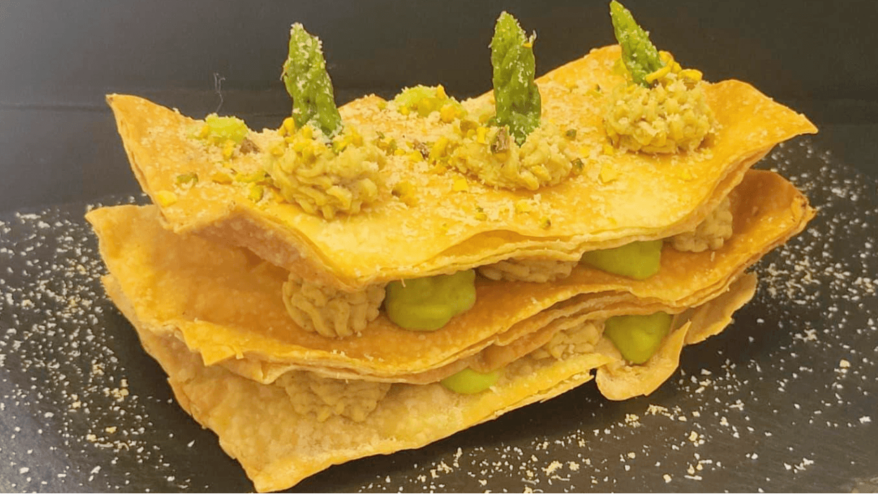 Sfoglie di pasta fillo intervallate da spuntoni di creme colorate su piatto nero ardesia