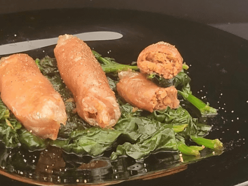 Piatto nero con 3 salsicce e spinaci