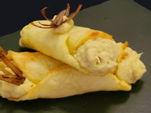 Due cannoli ripieni e sormontati da stick