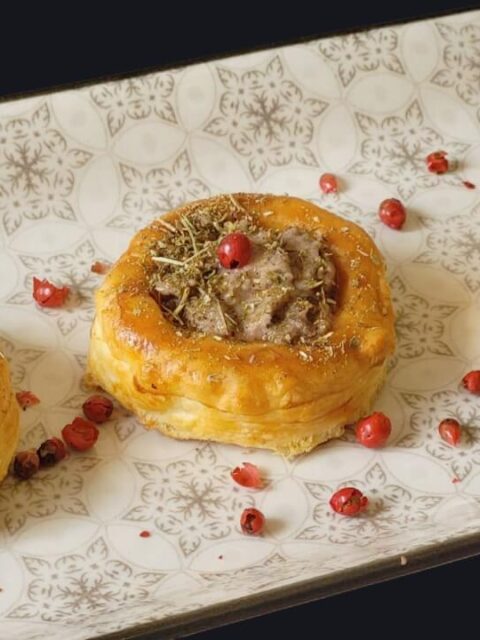 Piatto con 3 vol-au-vent farciti con sopra un granello di pepe rosa