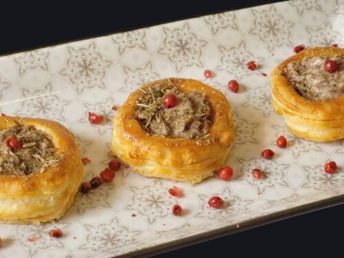 Piatto con 3 vol-au-vent farciti con sopra un granello di pepe rosa