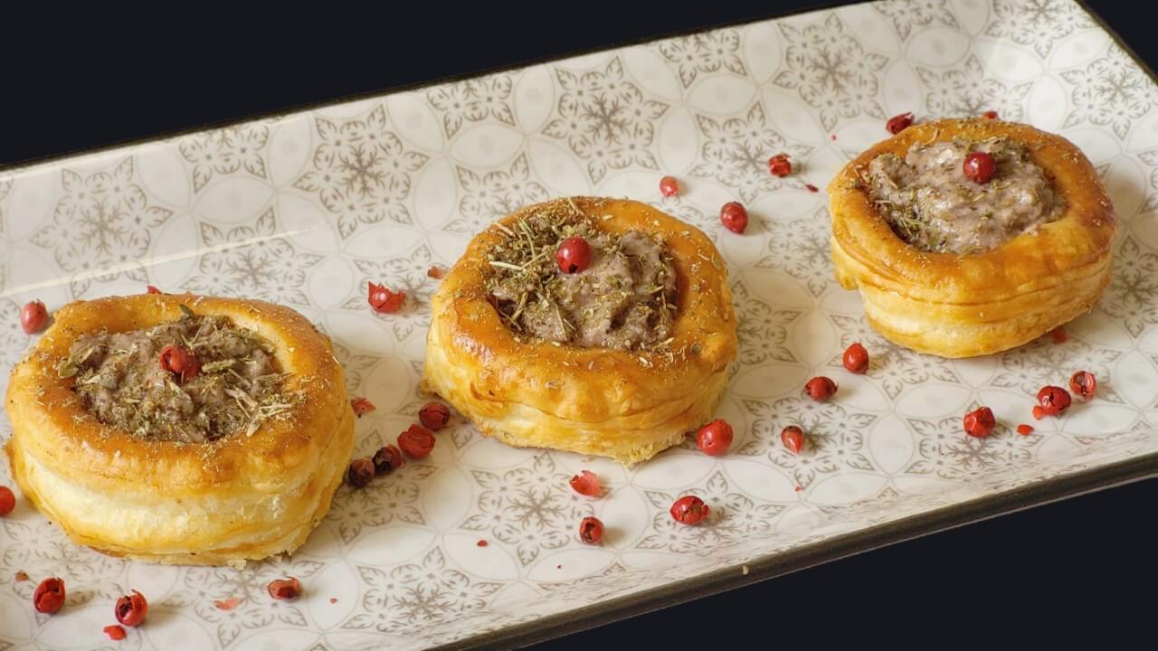 Piatto con 3 vol-au-vent farciti con sopra un granello di pepe rosa