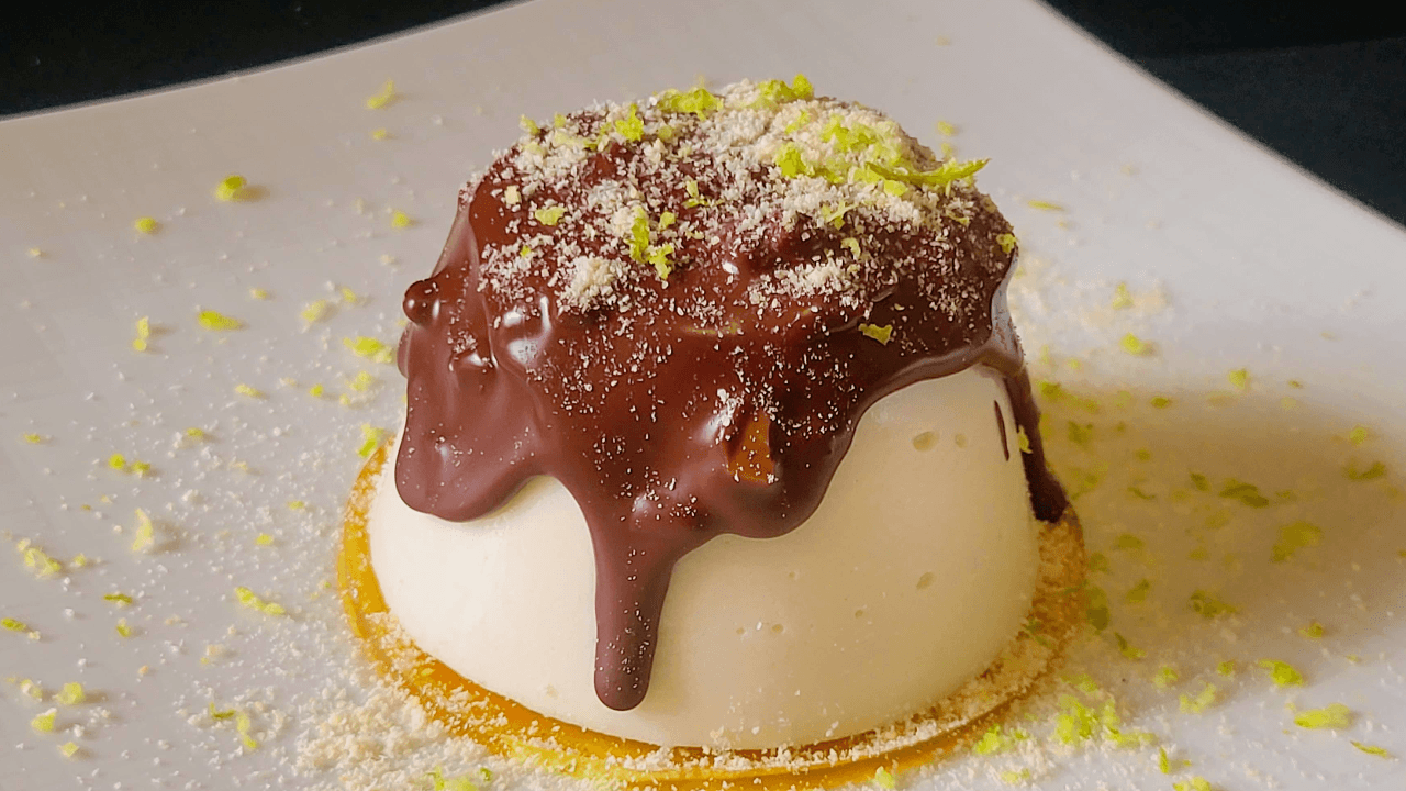 Panna cotta su gelatina gialla e sopra colata cioccolato su piatto bianco