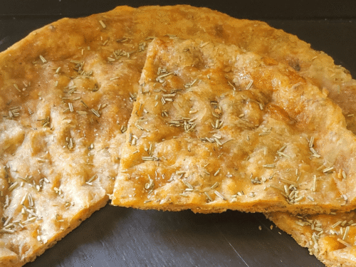 Pizza croccante con rosmarino su piatto ardesia nero