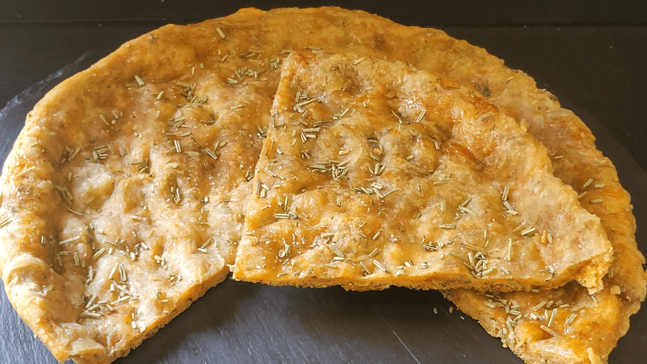 Pizza croccante con rosmarino su piatto ardesia nero