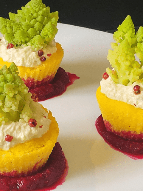 NIDI DI POLENTA GIALLA CON RICOTTA E CAVOLO ROMANESCO SU SALSA ROSSA BARBABIETOLA SU PIATTO BIANCO