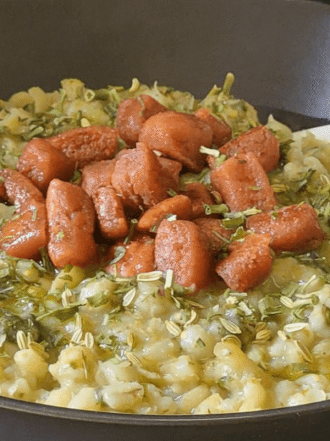 Zuppa orzo e fave su piatto scuro e prosciutto croccante e spezie
