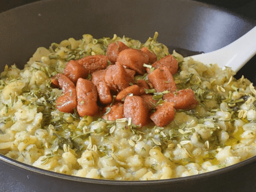Zuppa orzo e fave su piatto scuro e prosciutto croccante e spezie