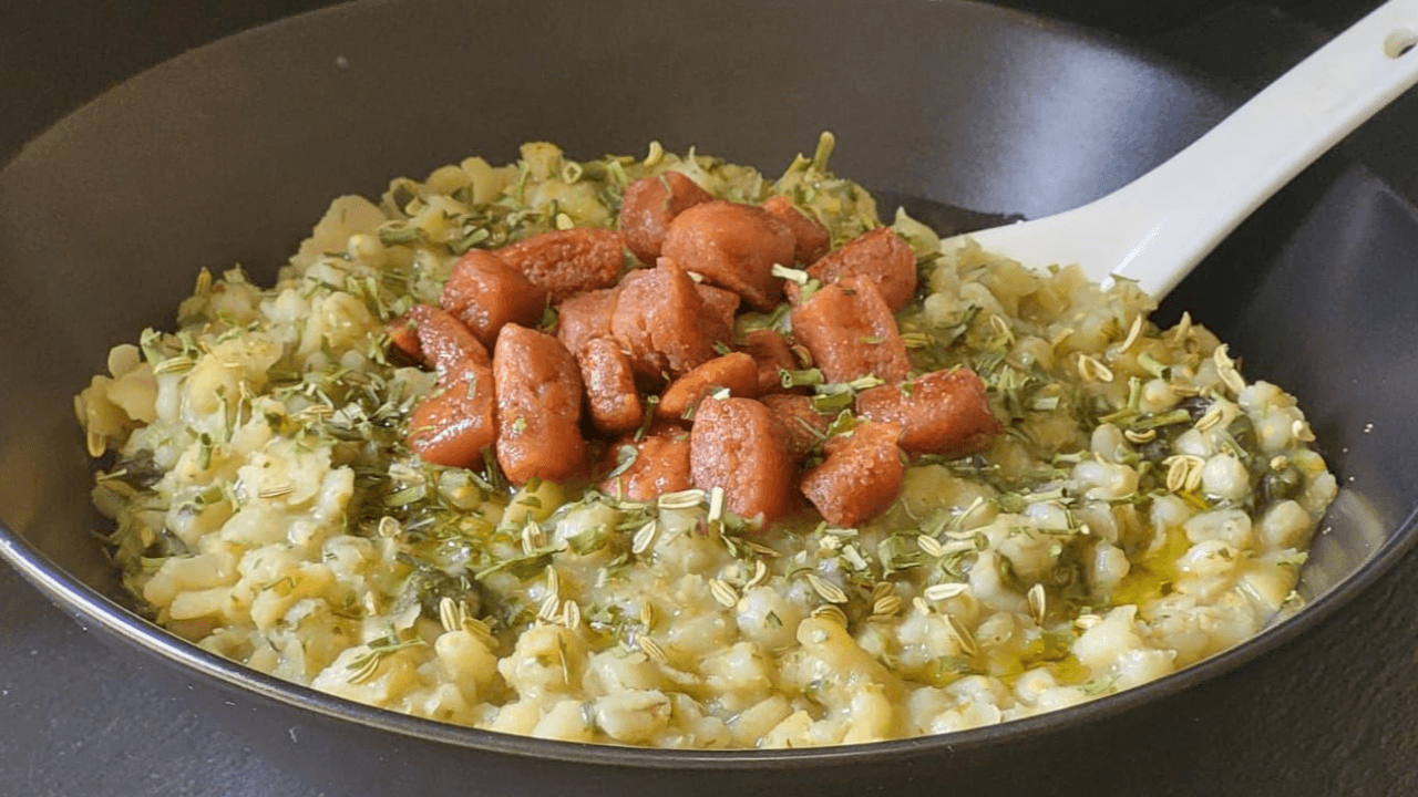 Zuppa orzo e fave su piatto scuro e prosciutto croccante e spezie