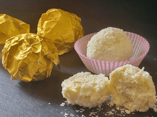 Sfere al cocco ripiene di mandorla su tagliere nero di ardesia
