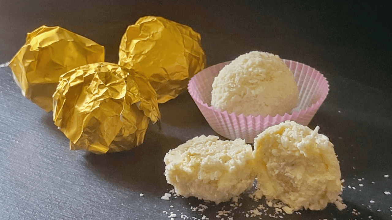 Sfere al cocco ripiene di mandorla su tagliere nero di ardesia
