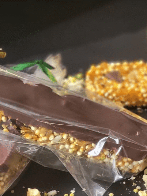 Barrette quinoa e cioccolato su piatto ardesia nero