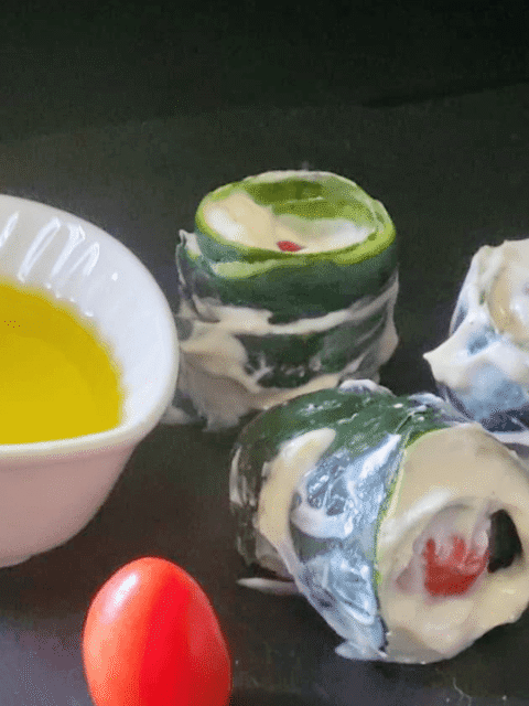 Rolls di bucce di cetrioli su piatto ardesia nera