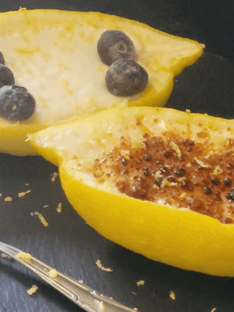 Dessert bianco dentro scorza limone su piatto ardesia nero