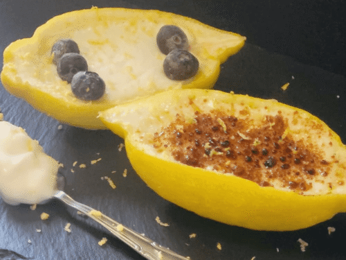 Dessert bianco dentro scorza limone su piatto ardesia nero