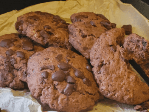 Cookies al cioccolato su carta forno e piatto ardesia nera