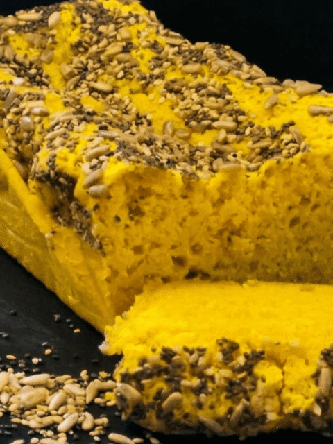 Pane giallo con semi su piatto ardesia nero