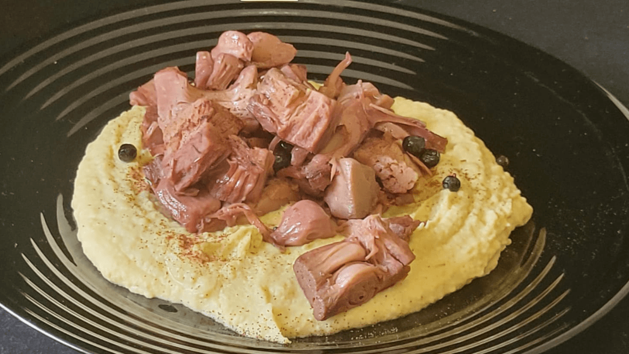 Jackfruit su hummus di ceci in piatto nero