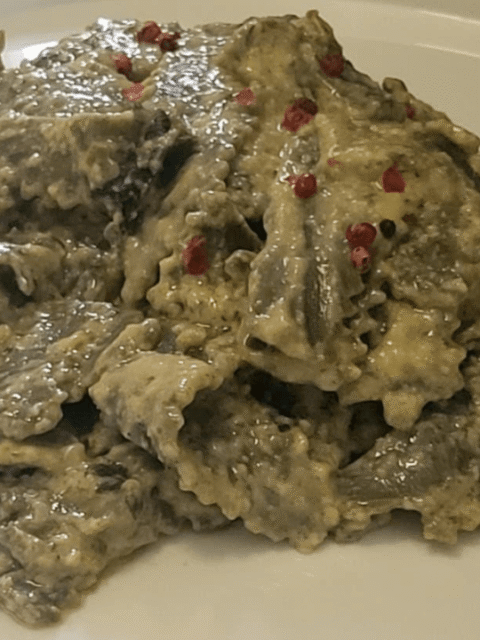 Maltagliati alle ortiche con panna e burro alla salvia su piatto bianco