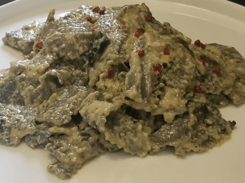 Maltagliati alle ortiche con panna e burro alla salvia su piatto bianco