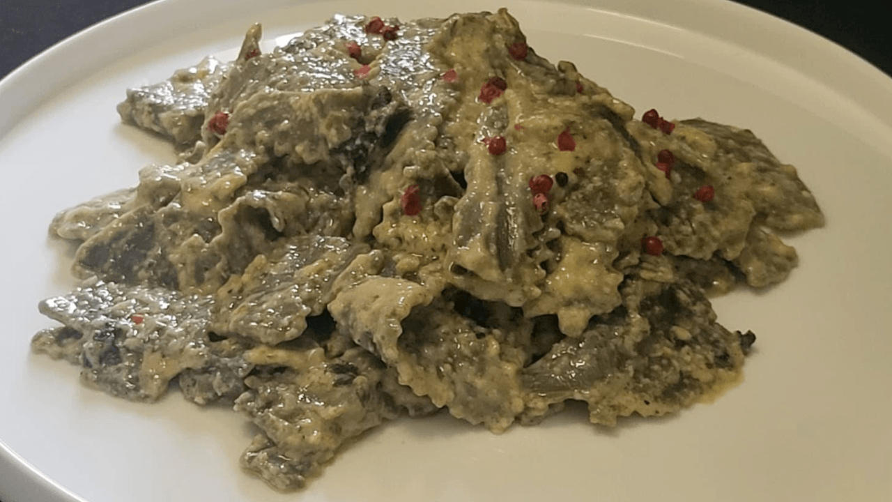 Maltagliati alle ortiche con panna e burro alla salvia su piatto bianco