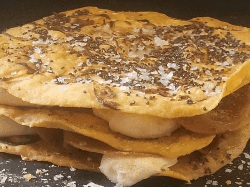 Focaccia a strati di pane lavash con spalmabile e affettato vegano gusto prosciutto su piatto ardesia nero