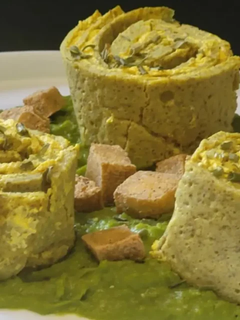Rotolini di crespelle con ricotta vegetale alla curcuma su crema di piselli e tofu croccante
