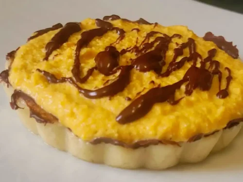 Crostatina crudista zucca e cioccolato su piatto bianco