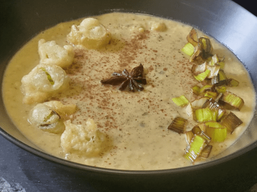 Ceci in brodo di magro con porri fritti,la ricetta medievale in versione vegana e moderna su piatto scuro
