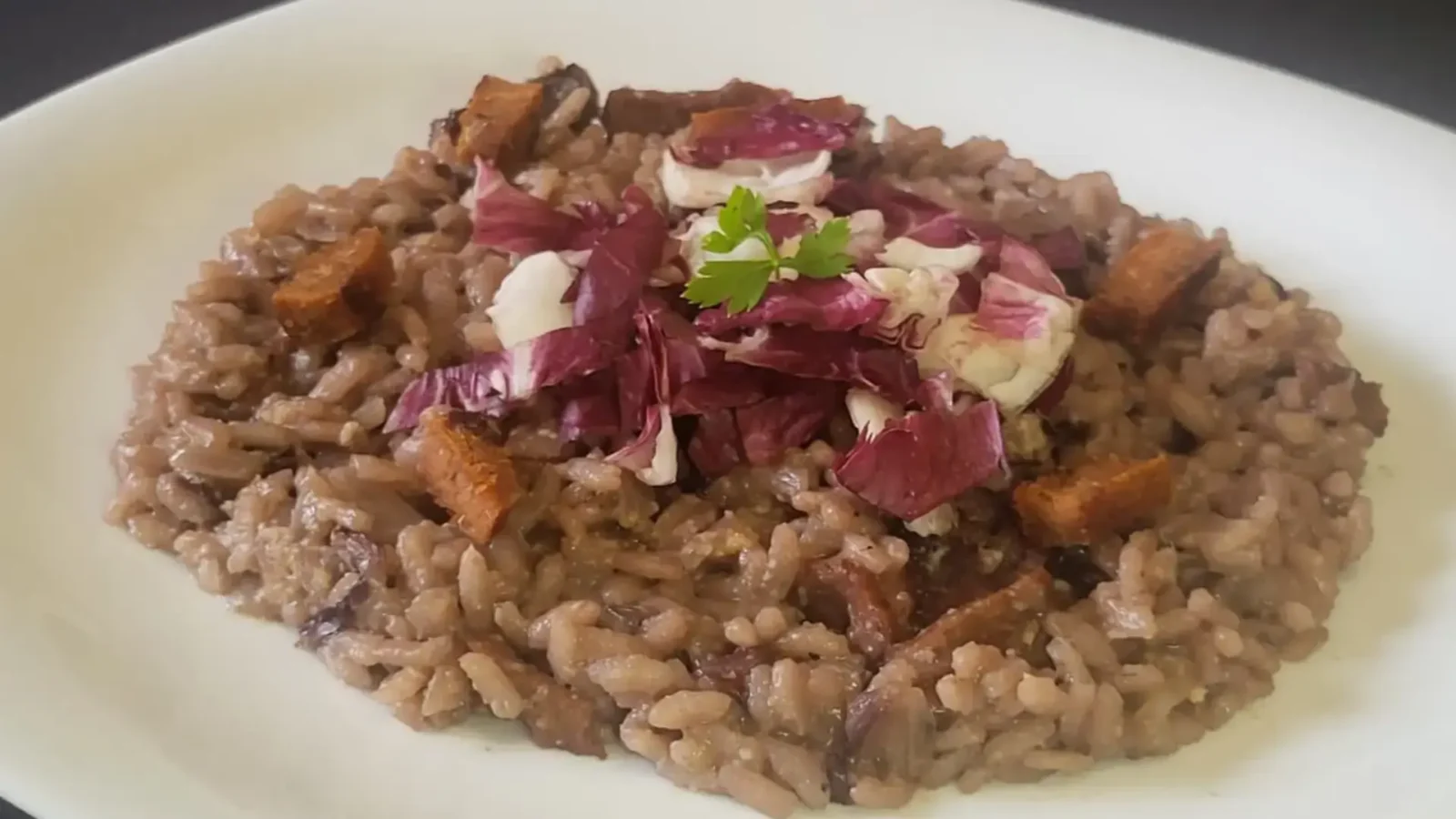 Risotto radicchio e pancetta affumicata, il grande classico veneto in versione vegana su piatto bianco